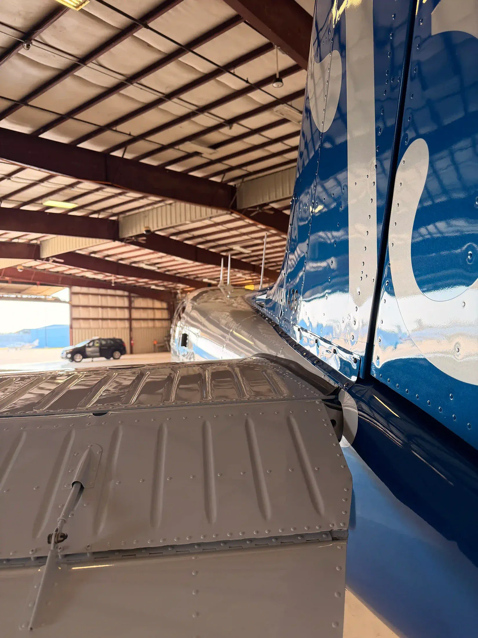 Technician machine-polishing the tail of a Beechcraft Bonanza to a deep gloss