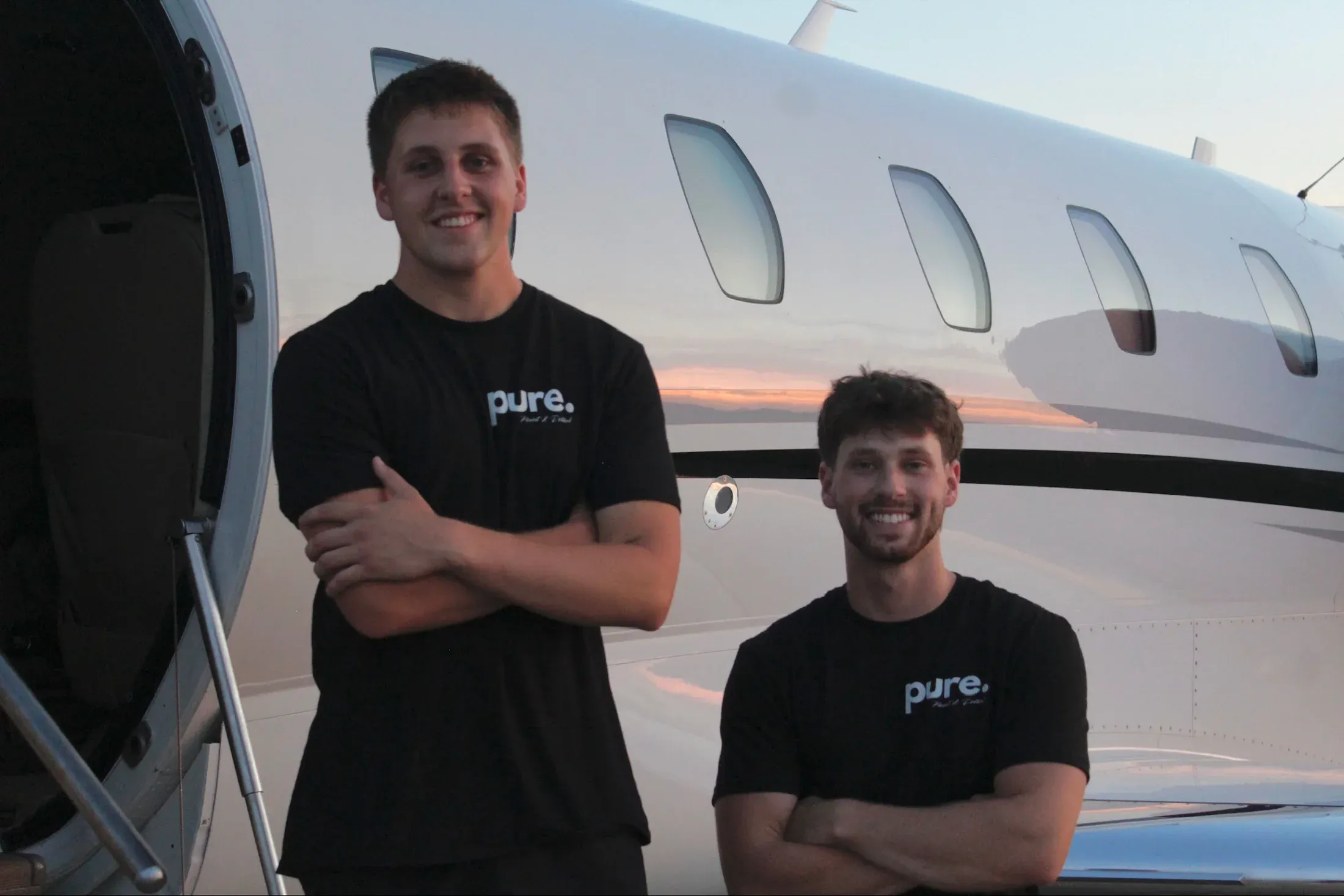 The insured Pure Aviation Detailing team beside a business jet